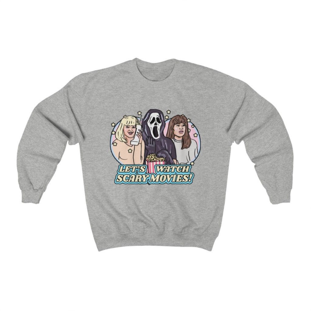 Product photo of heather grey crew neck sweatshirt with retro illustration of Casey Becker (Drew Barrymore), Sidney Prescott (Neve Campbell), and Ghostface eating popcorn together with text saying "Let's Watch Scary Movies!" below