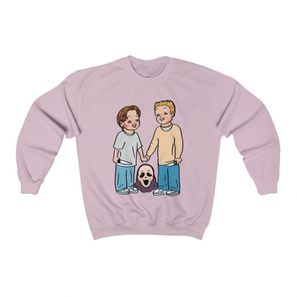 Product photo of pastel pink crew neck sweatshirt with retro illustration of Billy Loomis (Skeet Ulrich) and Stu Macher (Matthew Lillard) smiling and holding hands standing over a Ghostface mask on the ground between them